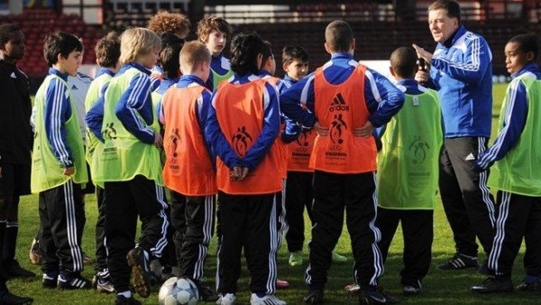 Entrenador de fútbol base hablando con sus jugadores